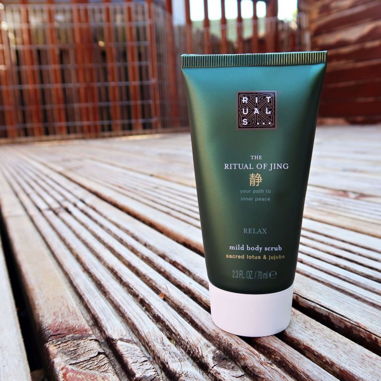 Rituals Ritual of Jing mild body scrub in green bottle sat on decking