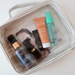 Beauty products flat laid inside a clear cover travel bag