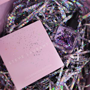 10th Birthday Edition Glossybox: small pink box with silver holographic detail sat on top of silver holographic shredded wrapping paper