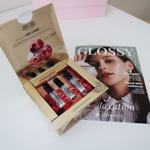 Gold box with open lid showing three mini perfume vials inside